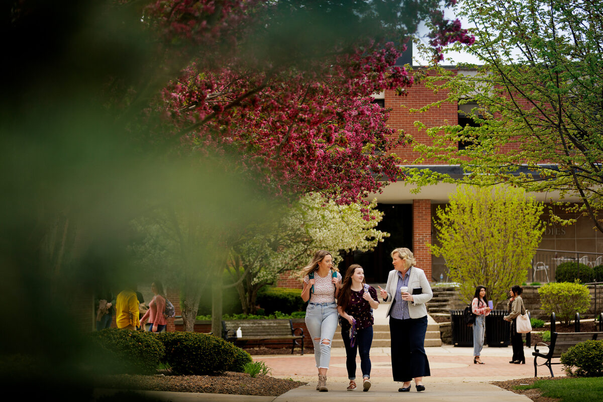 Faculty walking with two students