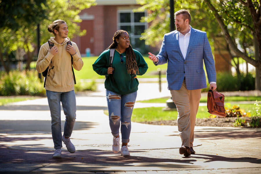 Vice president walking with two students outside