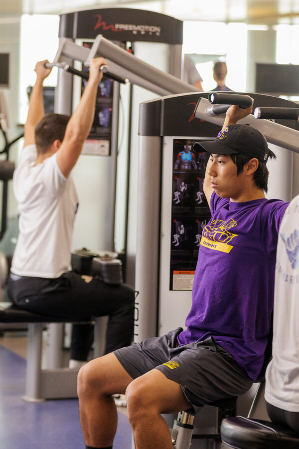 Students at the lat machines in the fitness center.