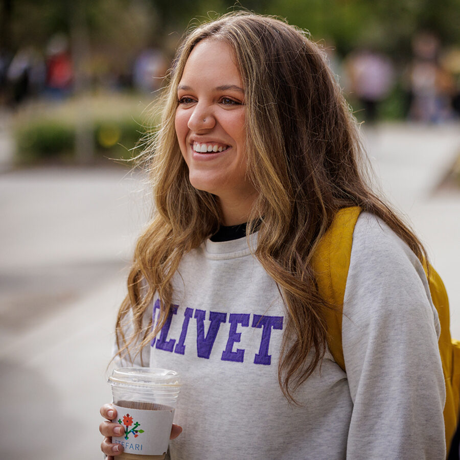 girl wearing Olivet sweatshirt holding coffee cup