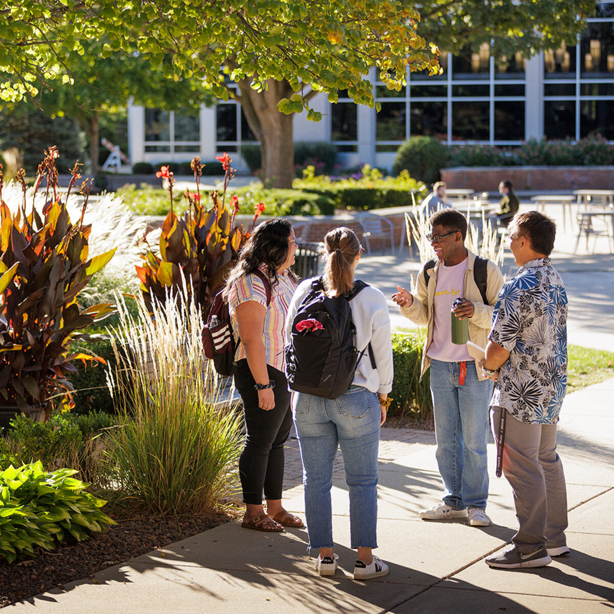 4 students talking on campus