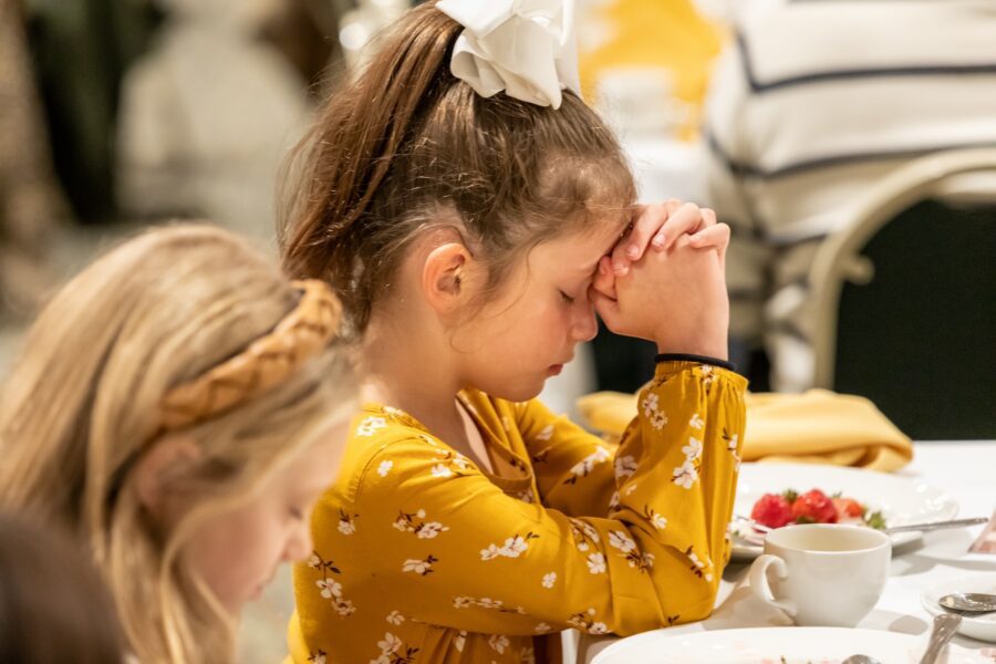 girl praying at breakfast