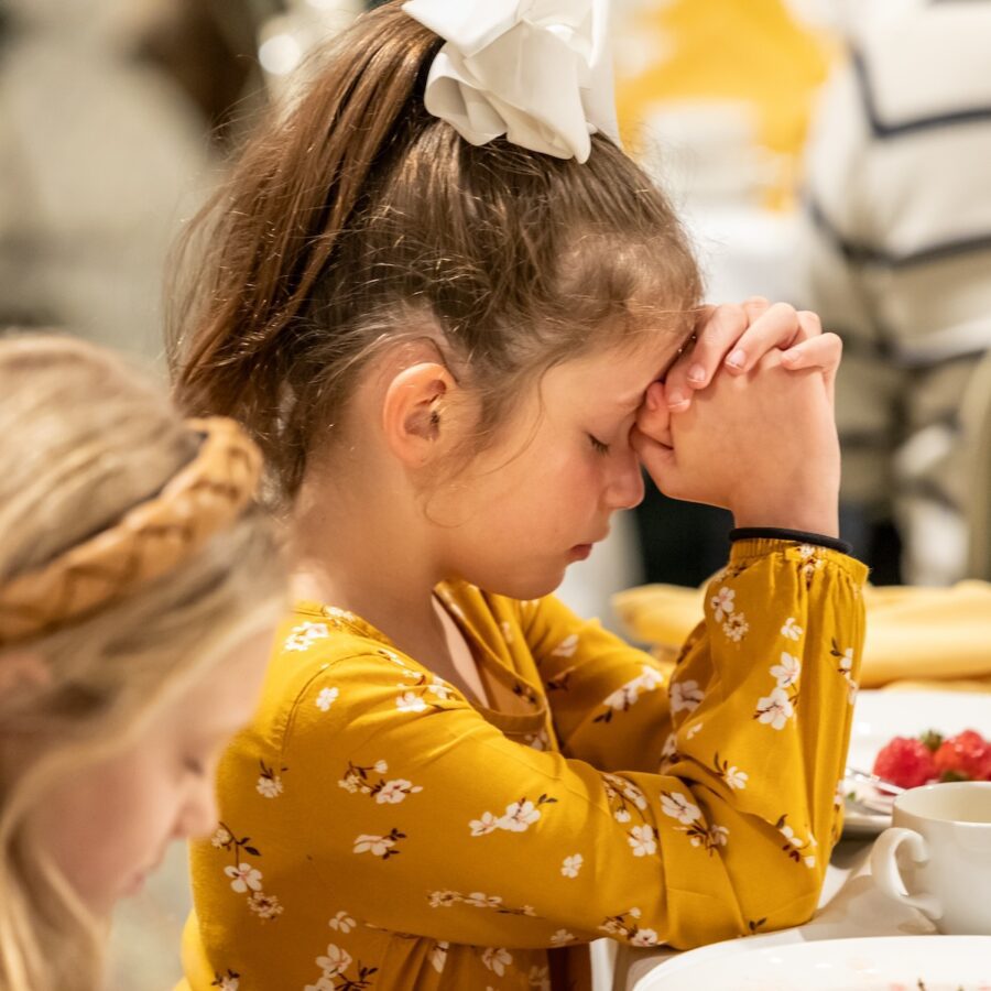 girl praying at breakfast