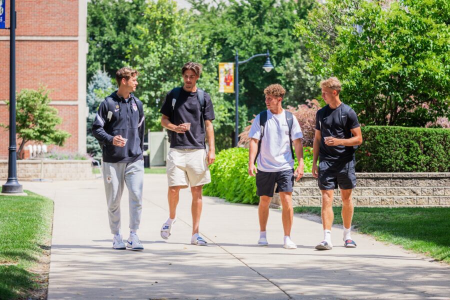 4 males walking on campus