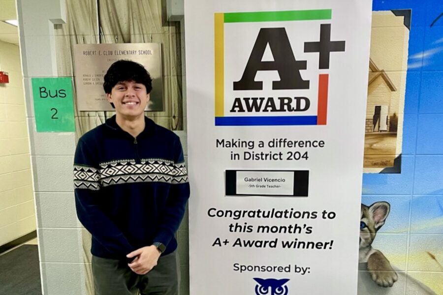 Alum standing in front of award sign